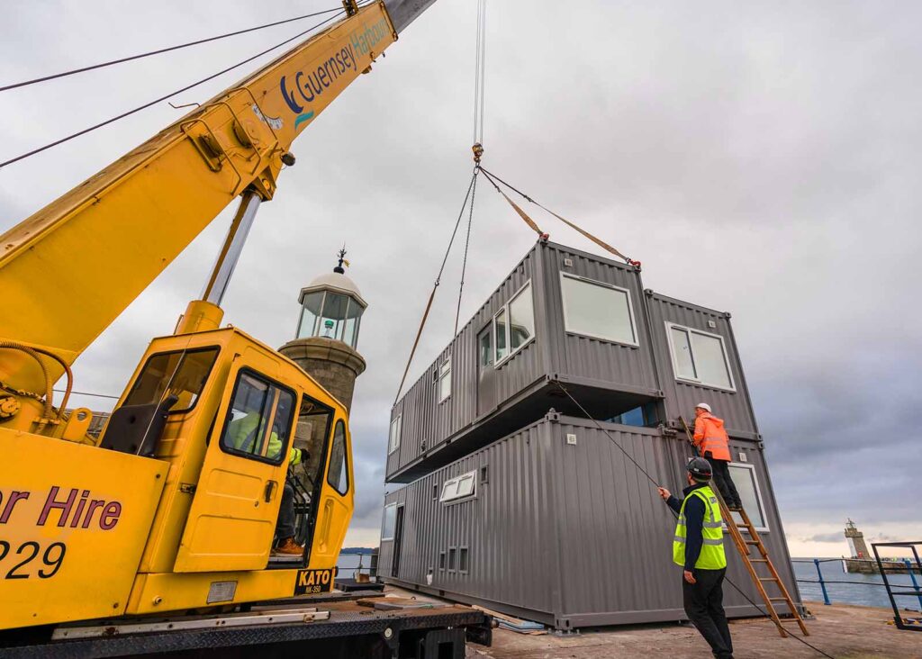 guernsey-horbours-crane lowered 40ft grey converted shipping container into position